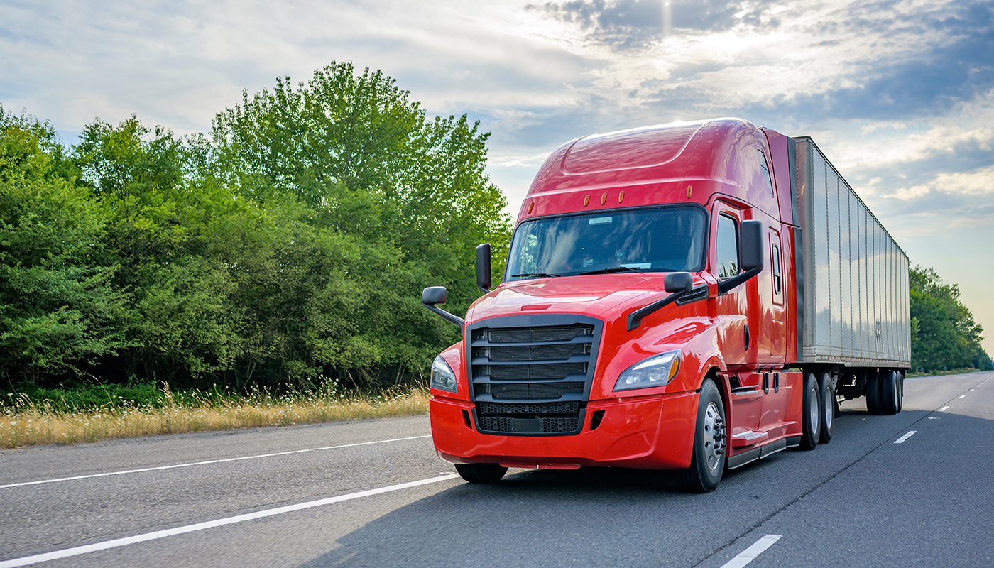 Red semi truck rolling on a highway