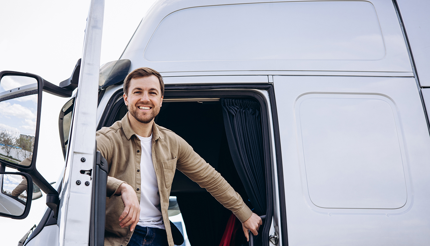 Smiling semi truck driver in the cab with the door open
