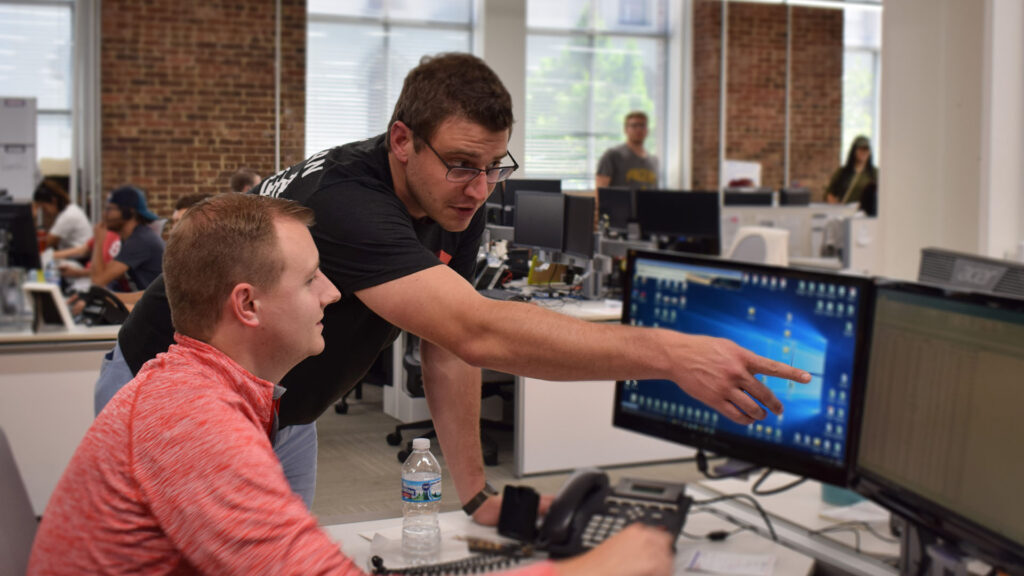 Spot freight broker working with a TMS employee on tracking freight